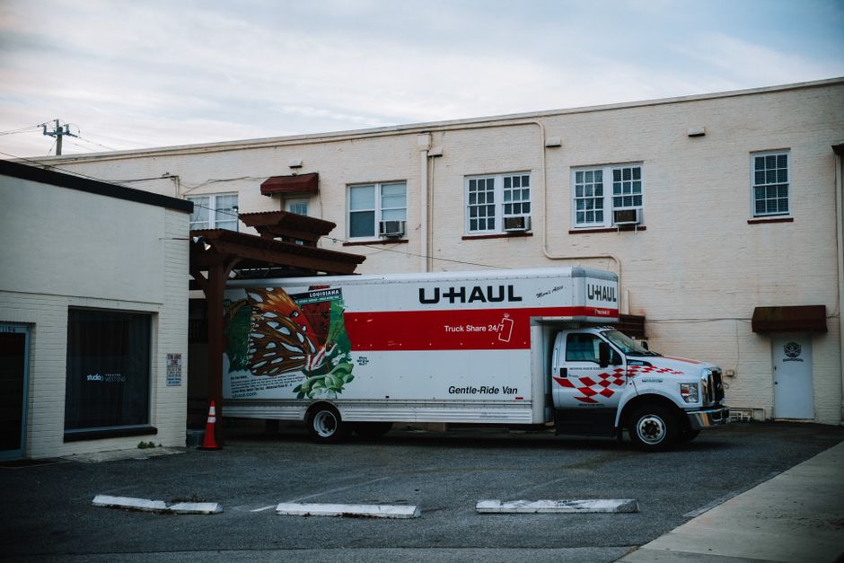 Professional movers loading a moving truck outside a residential home